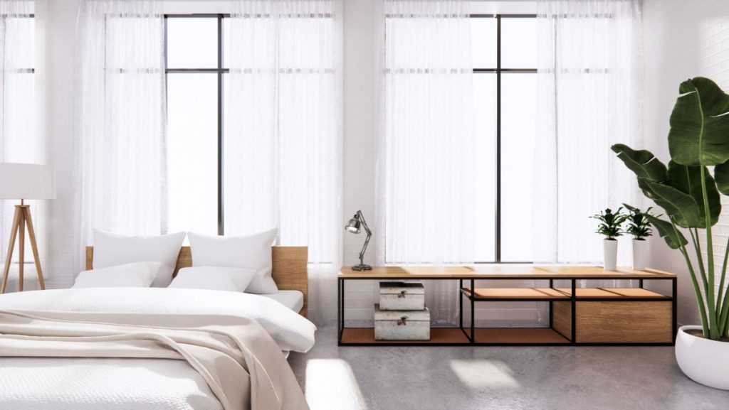 Imagen de un dormitorio limpio y organizado, con una estantería baja como mesita de noche y detalles naturales. Ambiente tranquilo y funcional. Visualiza tus espacios con J. Capmany Profesional 3D. Infografías 3D para interiorismo, arquitectura e inmobiliarias.