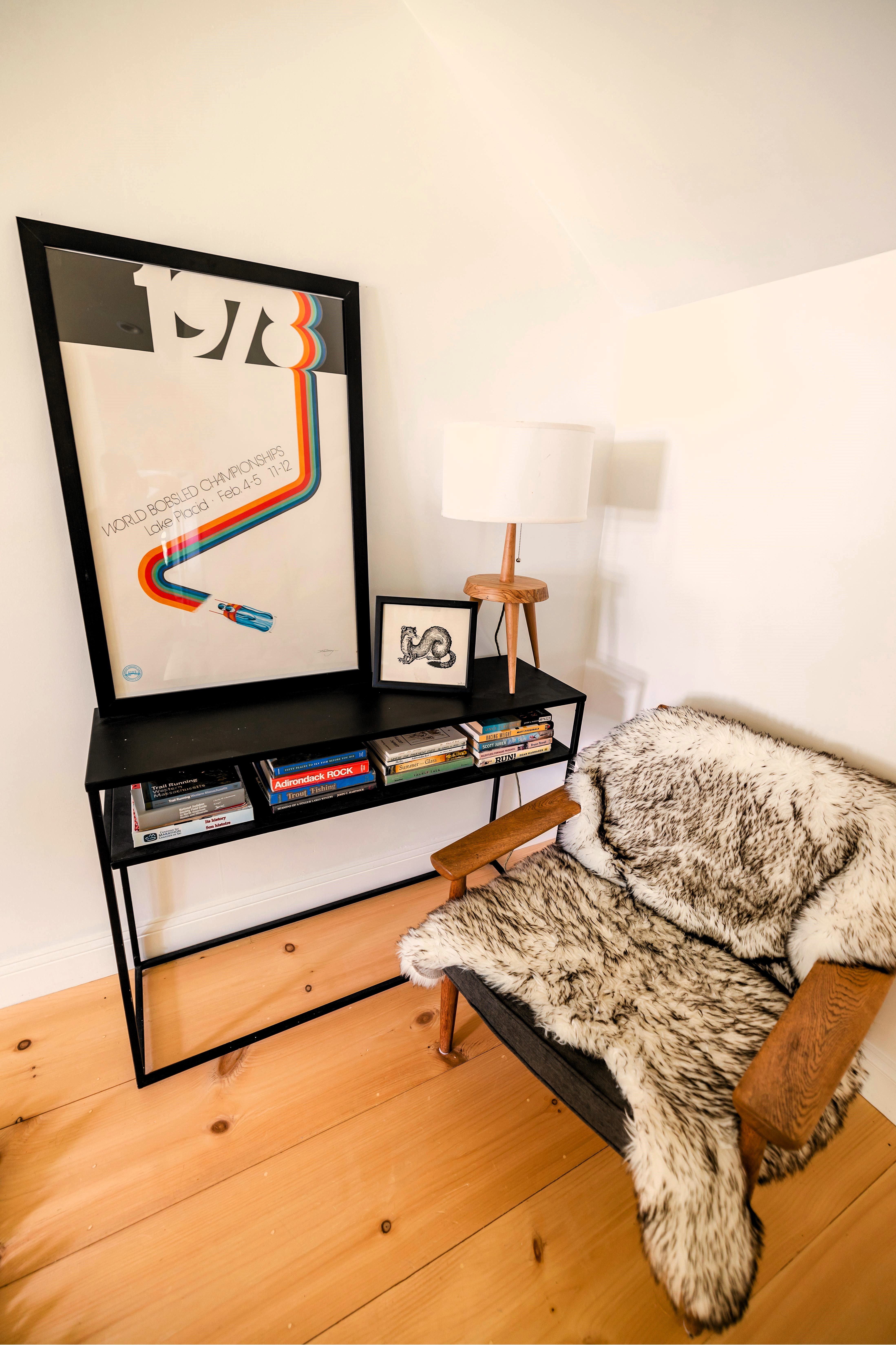 Mesa de pared de diseño industrial en metal, con una balda inferior para almacenar libros, ideal para crear un pequeño rincón de lectura en casa.