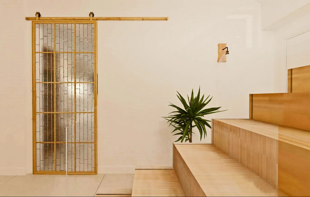 Infografía 3D de un hall pequeño que presenta una elegante escalera y una puerta oculta de madera y vidrio que de manera muy sutil invita a descubrir otro espacio