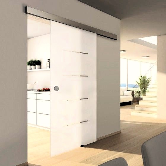 Cocina con puerta deslizante de cristal esmaltado que conecta con el pasillo, permitiendo el paso de luz natural.