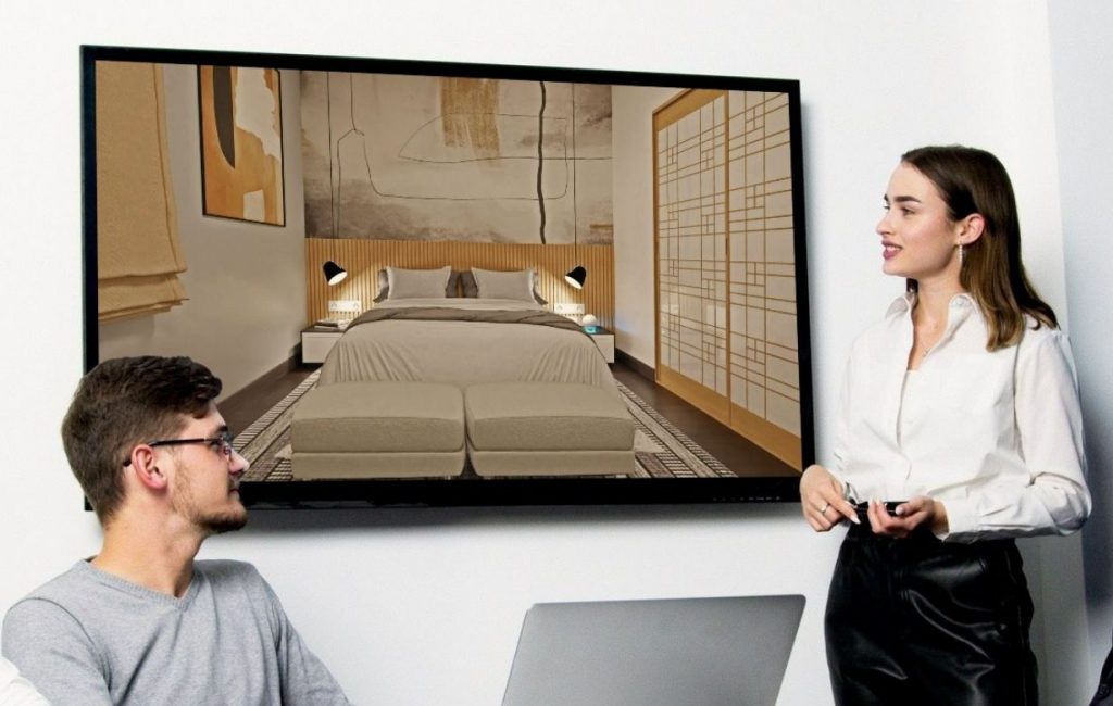 Un profesional presenta a un cliente un render 3D hiperrealista en una gran pantalla, destacando realismo y detalle en el diseño arquitectónico.